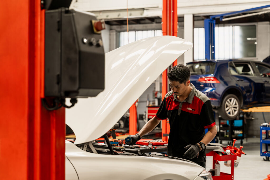Certified BMW technician at LeMans Motors Woolloongabba examining luxury vehicle